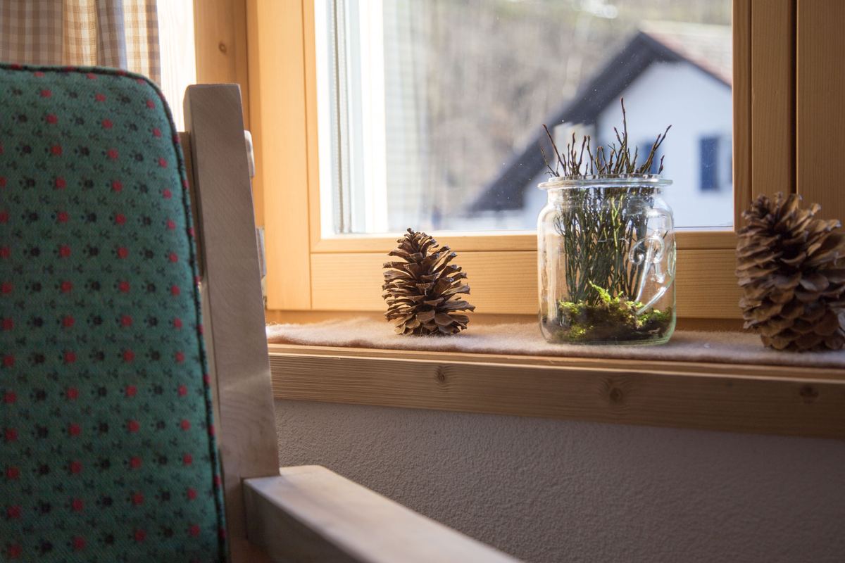 Fenstersims mit Zapfen und Blick auf die Häuser von Mellau