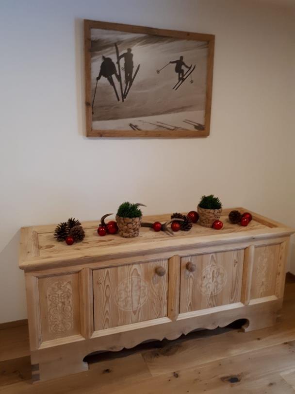 Sideboard aus Altholz mit herbstlicher Dekoration unter einem gerahmten Bild
