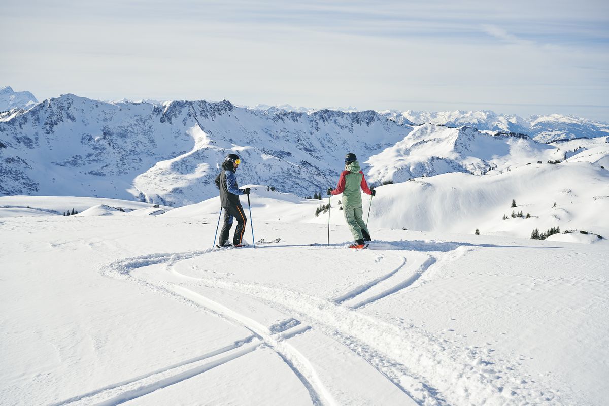 Zwei Skitourengeher auf einem weiten Schneefeld mit frischen Spuren im Skigebiet Damüls-Mellau